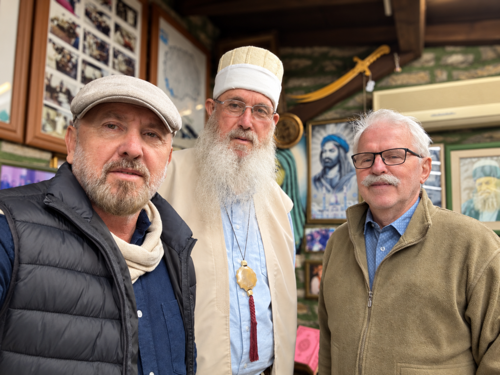 Arben Sulejmani, a Bektashi host and Robert Ince stand together in a room displaying photographs at Harabati Baba Tekke in Tetovo.